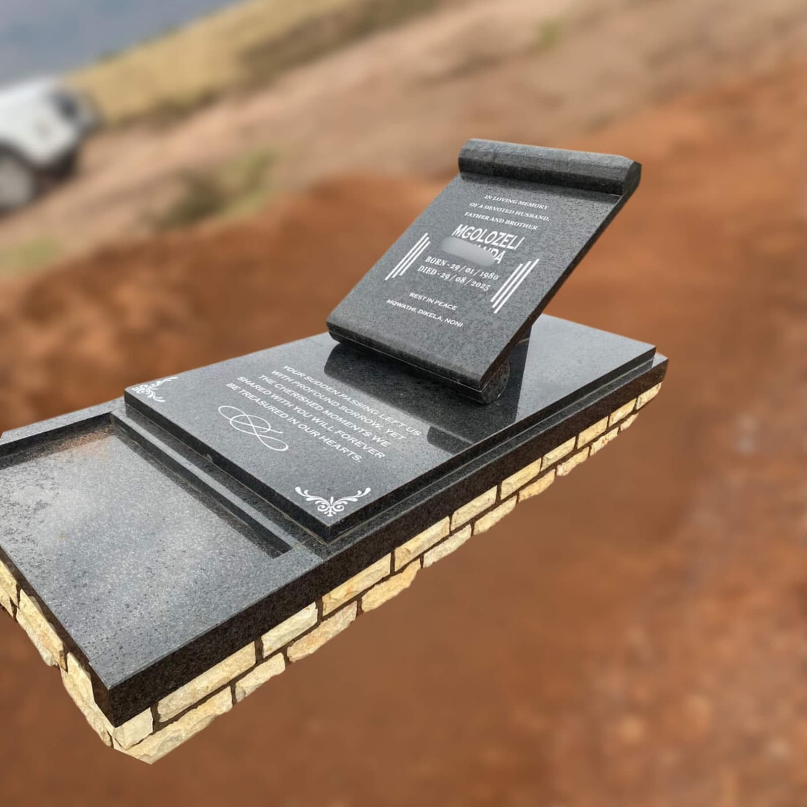 DEX 25 black granite tombstone on a brick base