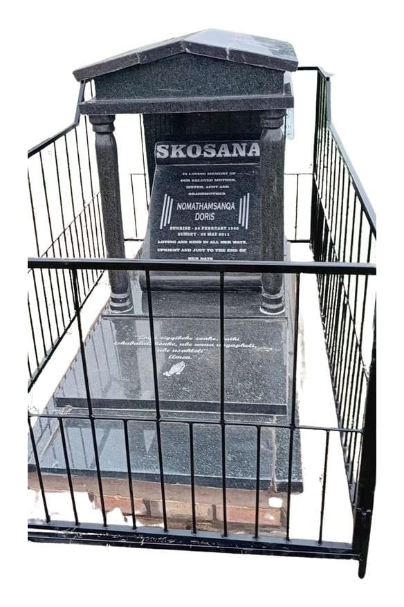 DEX 15 tombstone: gabled headstone with pillars, inside a steel fence