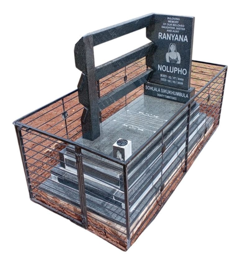 A black granite tombstone inside a steel tombstone fence