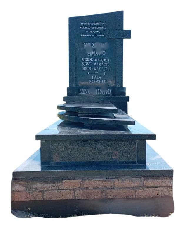 MAX 8 tombstone: cross headstone on curved stacked tiers above a brick base