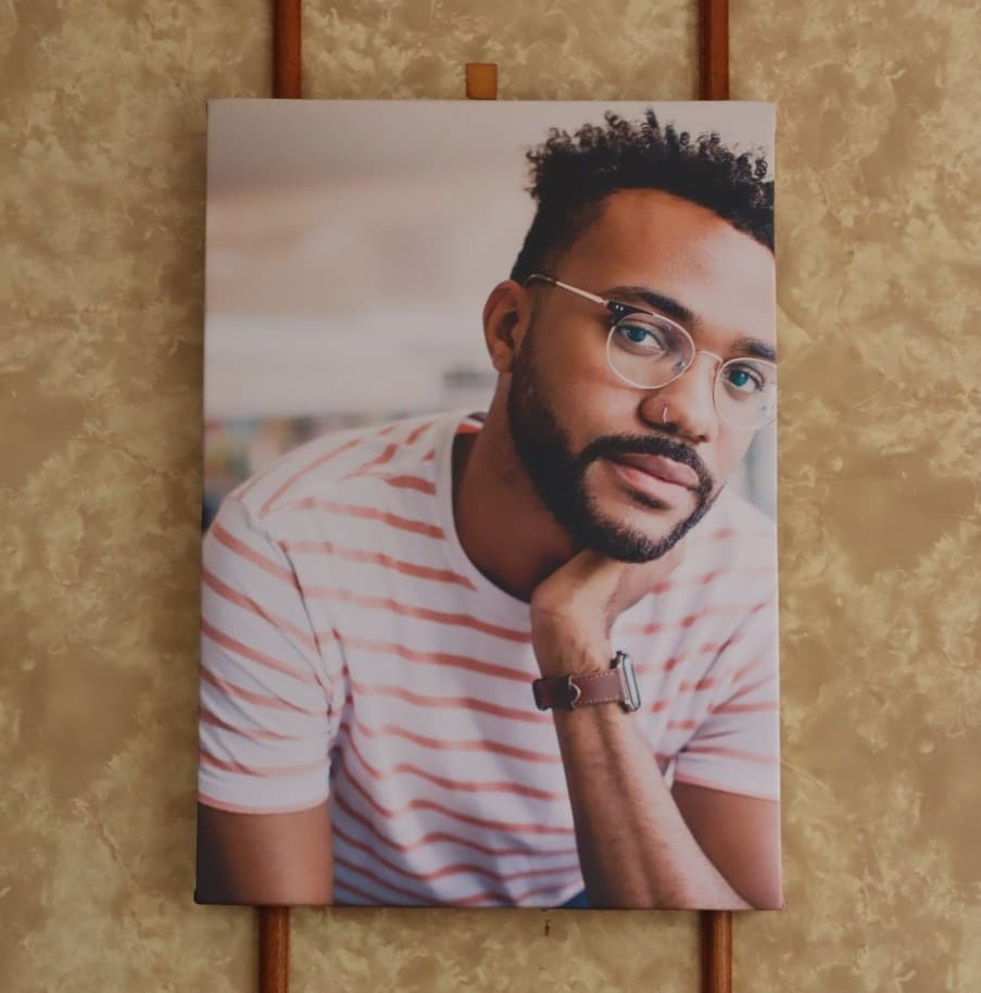 An A2 canvas print of a portrait, hanging on a wall